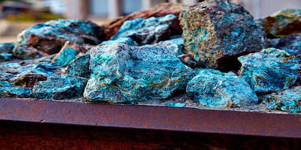 chunks of copper ore mineral rocks in an iron barrel